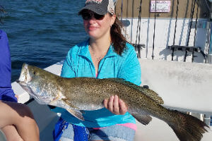Pretty young lady angler displays her large Weakfish caught on an inshore charter.