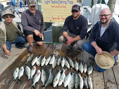 Mark Shaull and his boys Ben and Peter along with their friend Victor stand behind their day's catch at Teach's Lair Marina.
