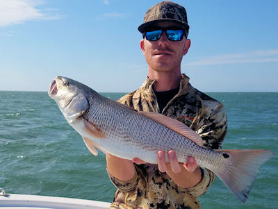 Angler holding a Redfish.