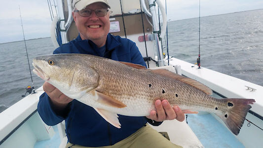 Angler holding large redfish.