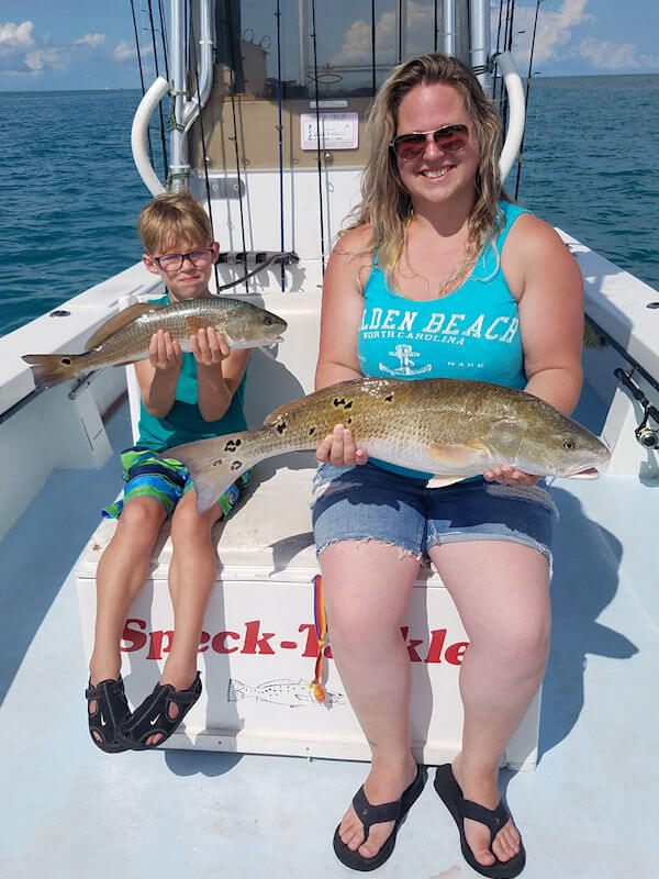 Young angler holds large Red Drum .