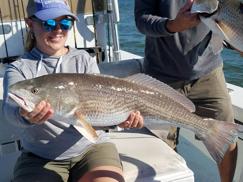 Brenna holds up a unique Red Drum with no spots on either side.